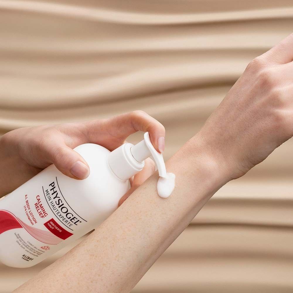 Eine Hand drückt Lotion aus einer PHYSIOGEL® Flasche auf den Unterarm.