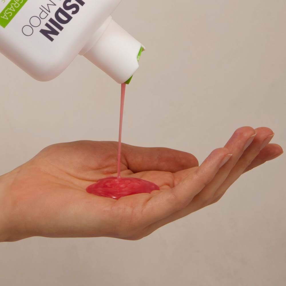 ISDIN Nutradeica Shampoo wird in eine Handfläche gegossen.