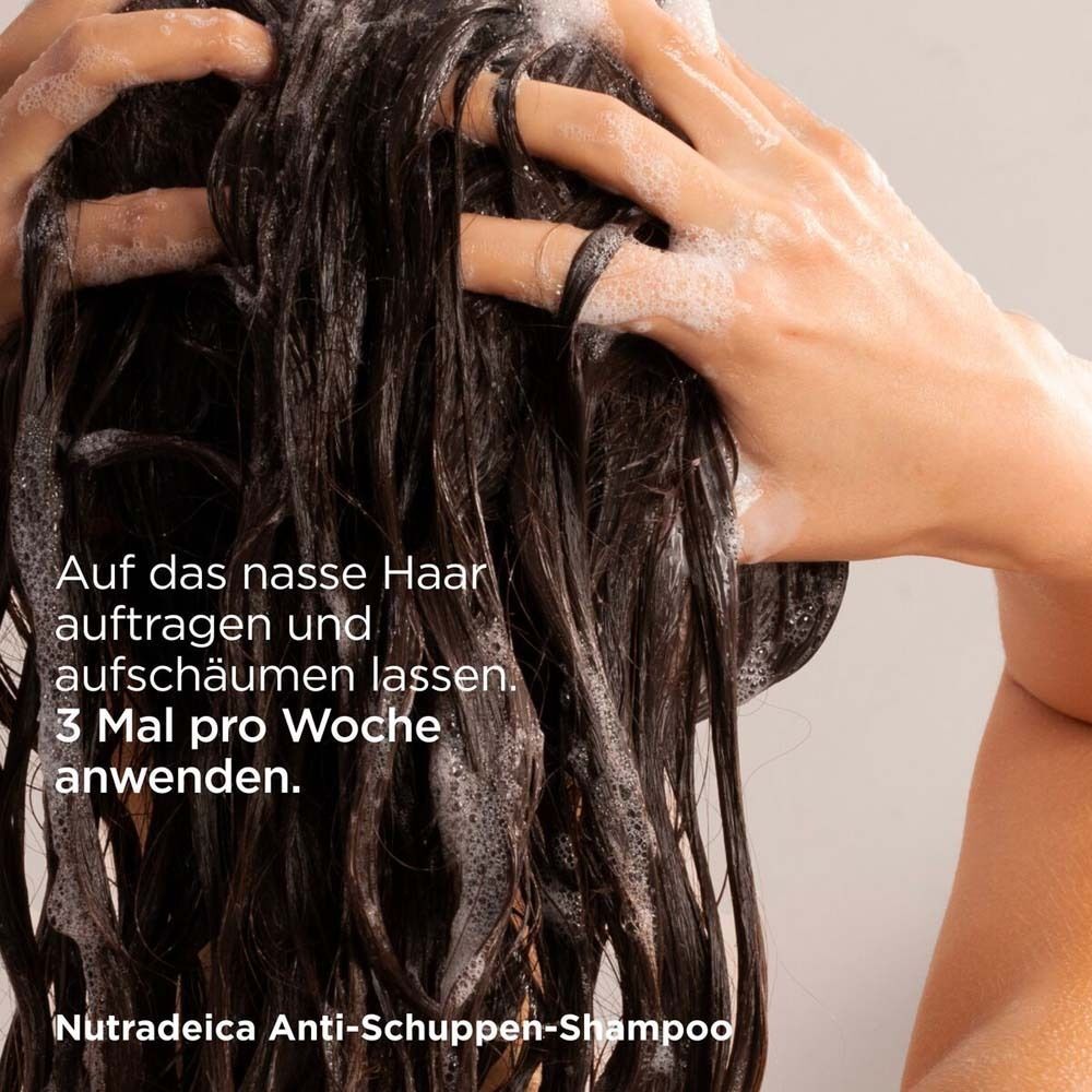 Eine Person massiert ISDIN Nutradeica Anti-Schuppen-Shampoo in das nasse Haar ein.