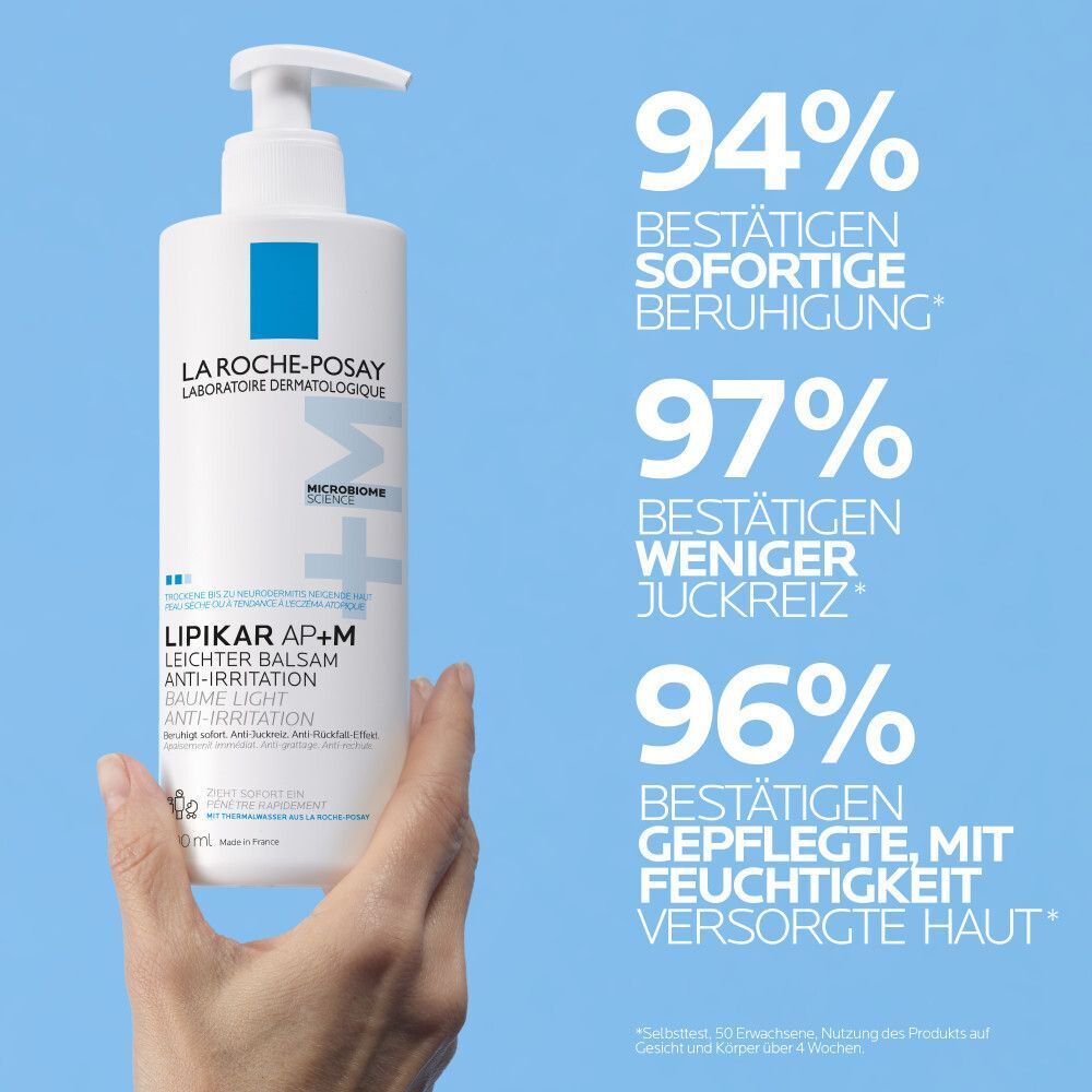Hand hält La Roche Posay Lipikar Leichter Balsam AP+M Flasche, mit Prozentangaben.