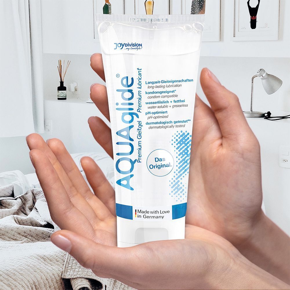 Hände halten eine AQUAGLIDE Premium Gleitgel Tube.