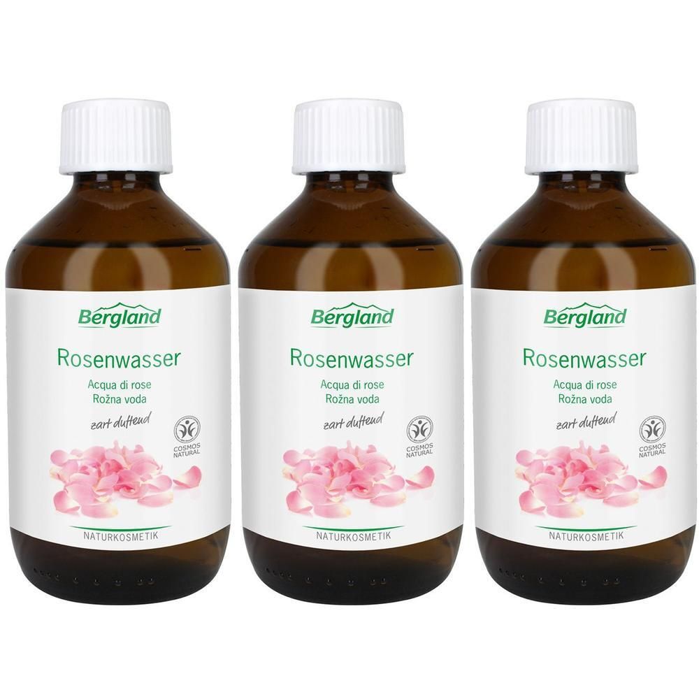 Drei Flaschen Bergland Rosenwasser mit weißen Verschlüssen und Etiketten, die Rosenblüten zeigen.