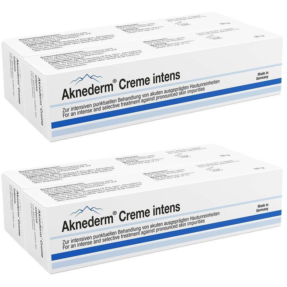 Zwei Packungen Aknederm® Creme intens. Weiße Kartons mit blauer Banderole und Bergmotiv.