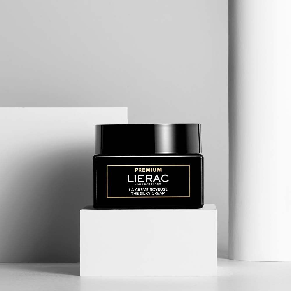 Ein LIERAC Premium Seidige Creme Tiegel auf einem weißen Würfel, minimalistische Präsentation.