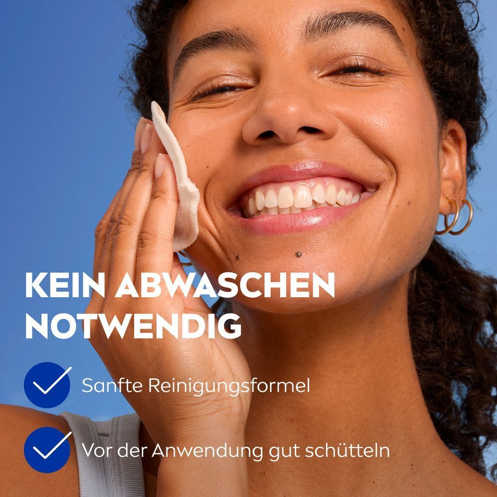 Frau reinigt ihr Gesicht. Kein Abwaschen notwendig. Sanfte Reinigungsformel, vor Gebrauch schütteln.