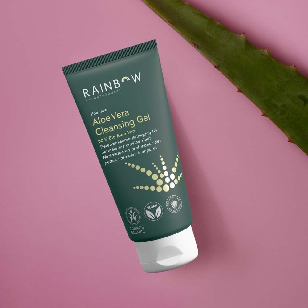 Eine Tube Rainbow aloecare Aloe Vera Cleansing Gel neben einem Aloe Vera Blatt.