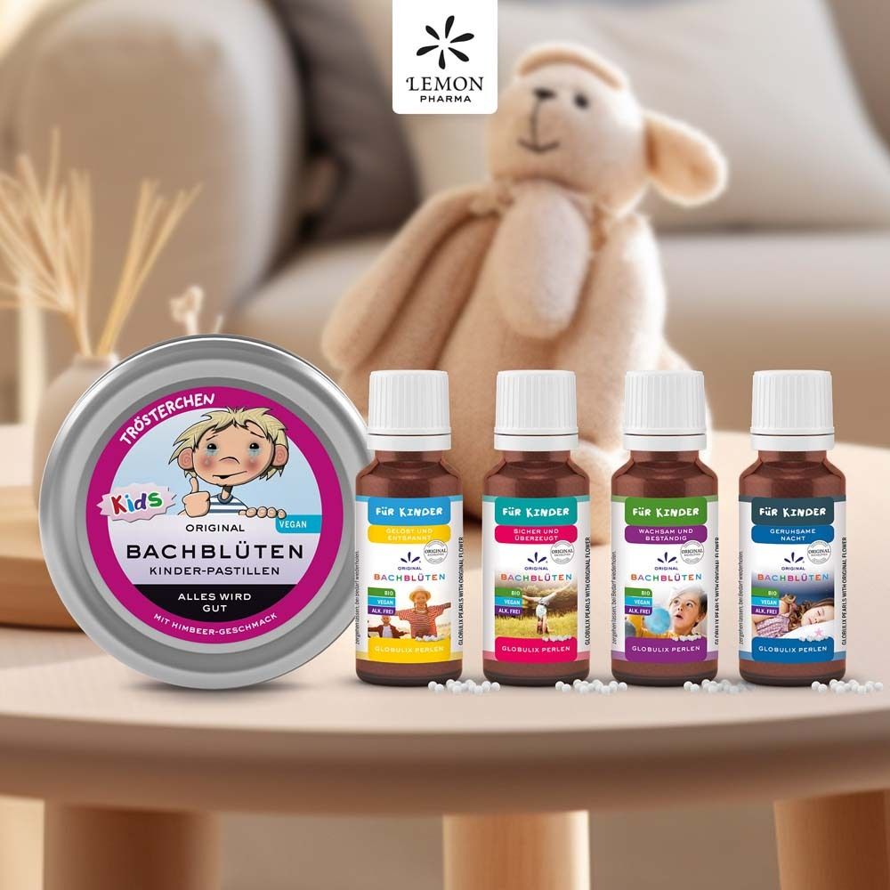 Produkt-Arrangement mit Dose und Fläschchen. Dose: rund, silber, rosa Deckel. Fläschchen: braun, Etikett mit Text. Hintergrund: Tisch mit Deko.