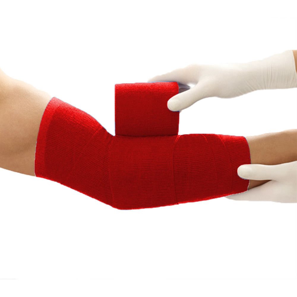 Rote elastische Bandage am Arm. Hände mit weißen Handschuhen halten die Bandage. Der Arm ist teilweise bandagiert.