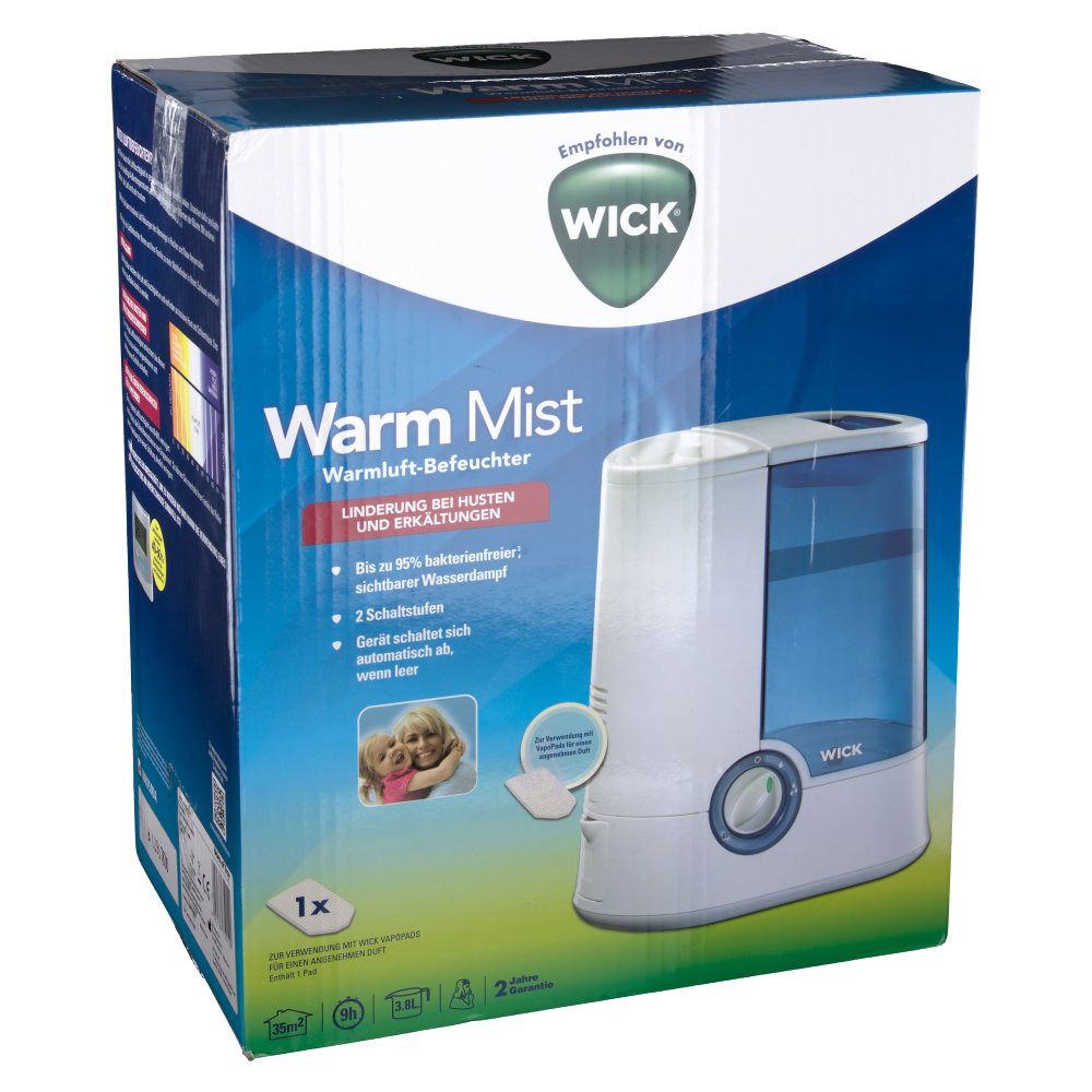 Luftbefeuchter in Verpackung. Weiß-blaue Box mit Produktabbildung und Text. Logo: WICK. Text: Warm Mist, Linderung bei Husten und Erkältungen.
