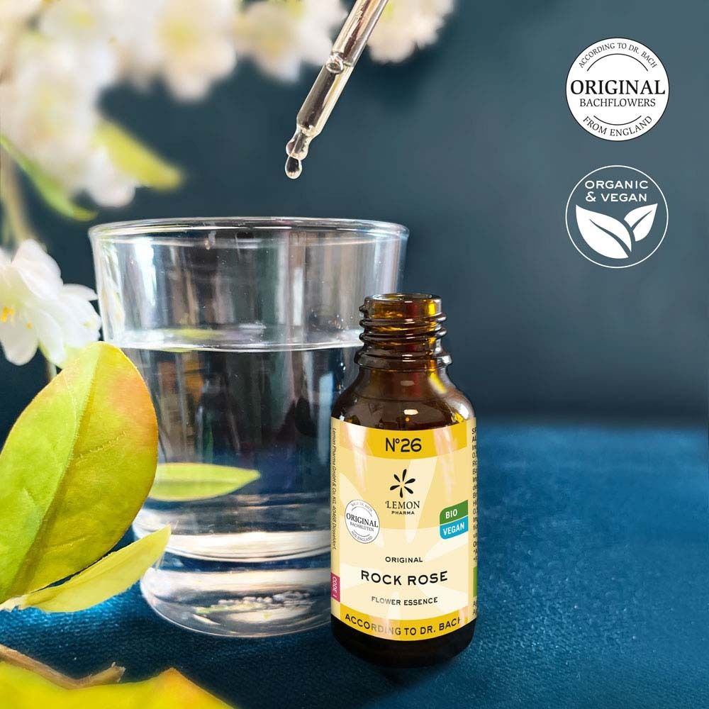 Braune Glasflasche mit gelbem Etikett neben einem Glas Wasser. Aufschrift: N°26 Rock Rose Flower Essence. Mit Tropfer. Bio und Vegan.