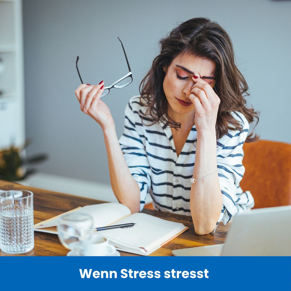 Frau am Schreibtisch, hält Brille, berührt Stirn. Text: Wenn Stress stresst.