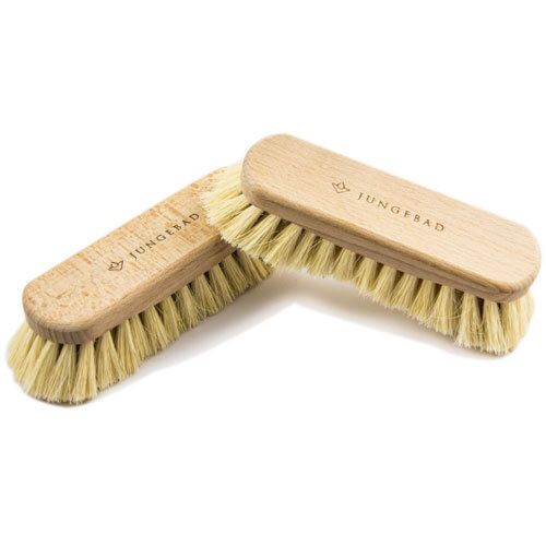 Zwei rechteckige Bürsten aus Holz mit hellen Borsten. Auf der Oberseite steht „JUNGEBAD“.