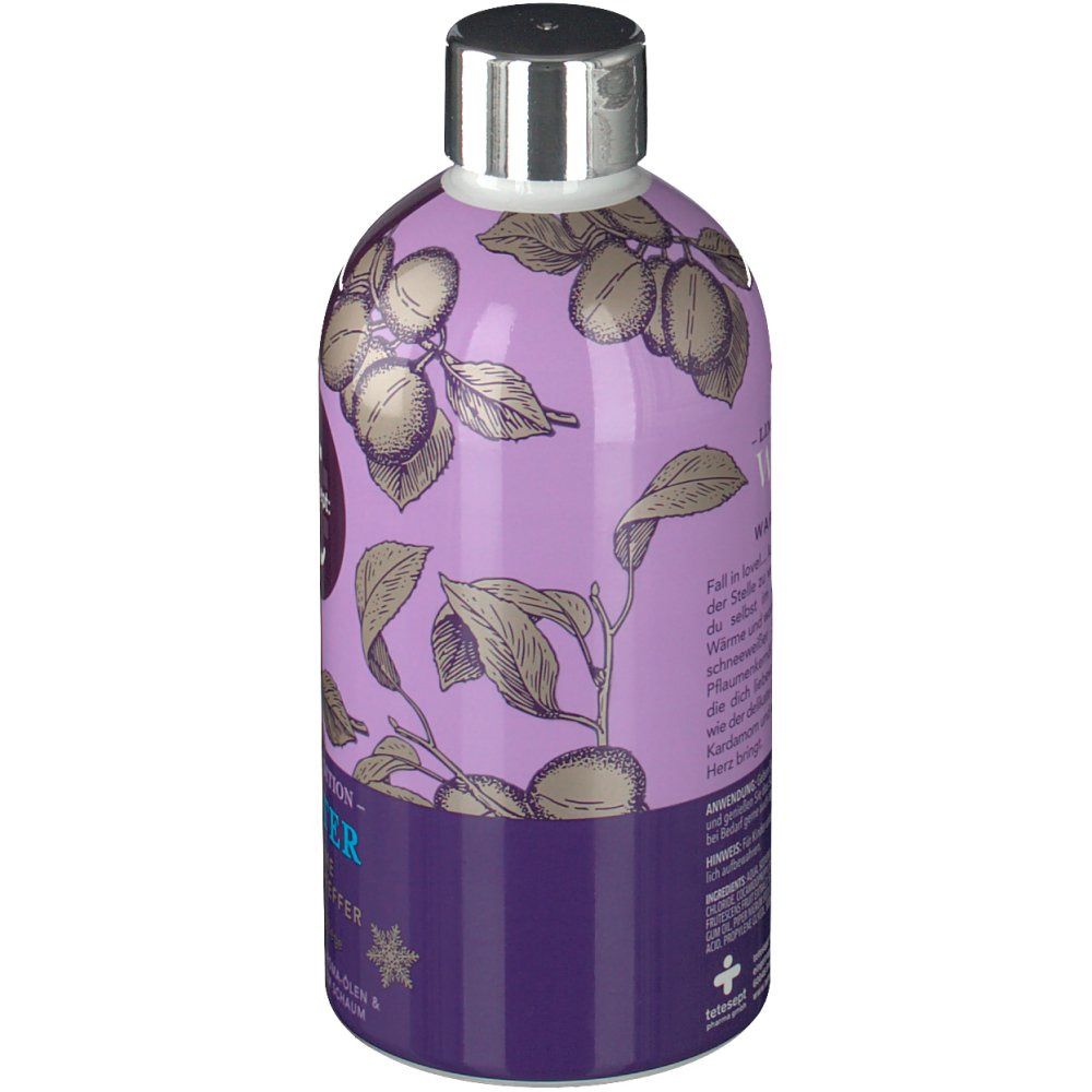 Flasche mit lila Etikett. Rückseite mit Text und Illustration von Pflaumen und Blättern.