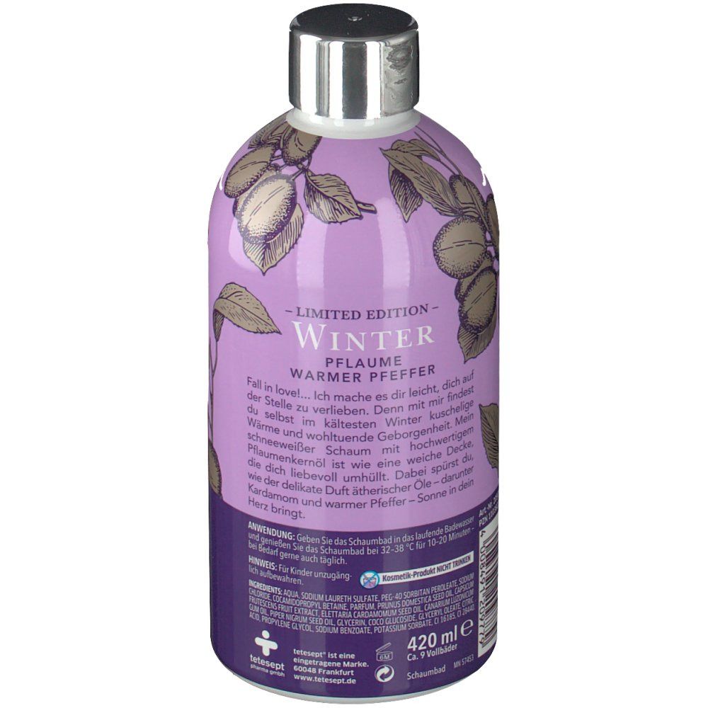 Flasche mit lila Etikett. Rückseite mit Text, Illustration von Pflaumen und Blättern, und Volumenangabe.