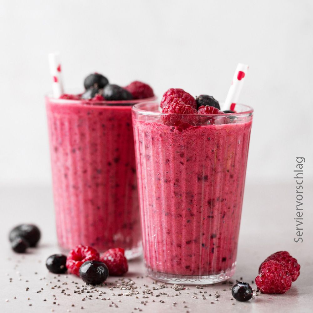 Zwei Gläser mit pinkfarbenem Smoothie. Beeren und Samen.