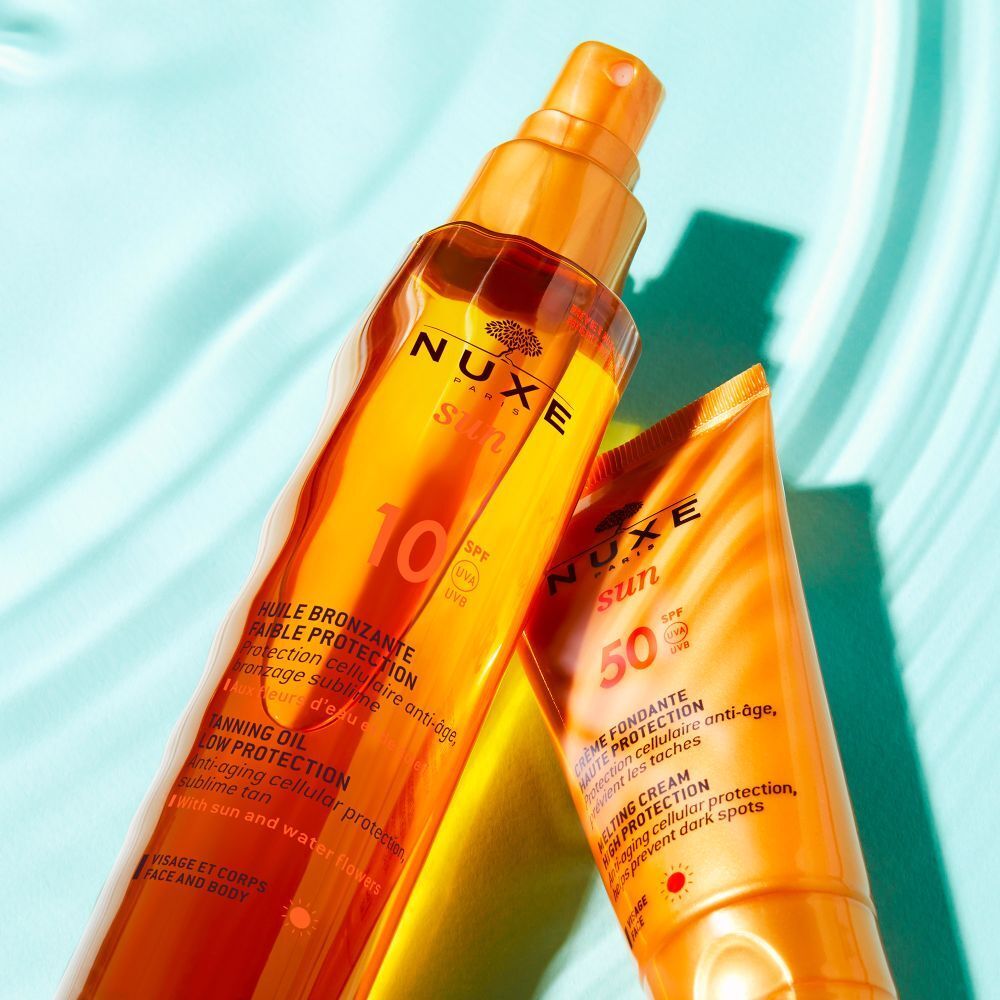 NUXE Sun Öl und Spray. Flaschen in Gold- und Orangetönen. Text: Huile Bronzante, Spray Fondant Haute Protection.