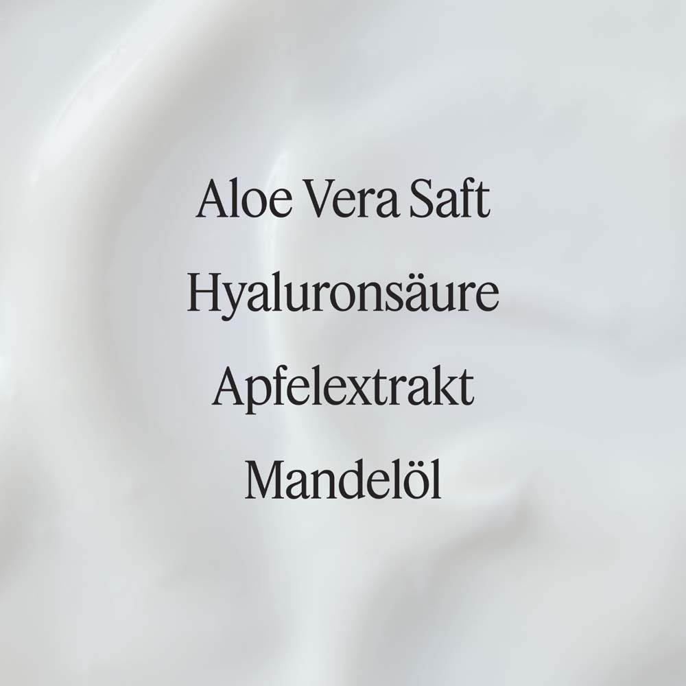 Nahaufnahme von Creme. Text: Aloe Vera Saft, Hyaluronsäure, Apfelextrakt, Mandelöl. Weiße, cremige Textur.