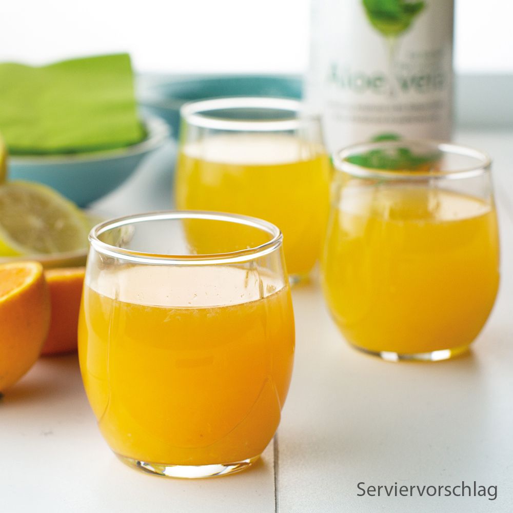 Drei Gläser mit gelbem Getränk. Servierbeispiel. Auf einem Tisch, mit Zitronen und Orangen im Hintergrund.