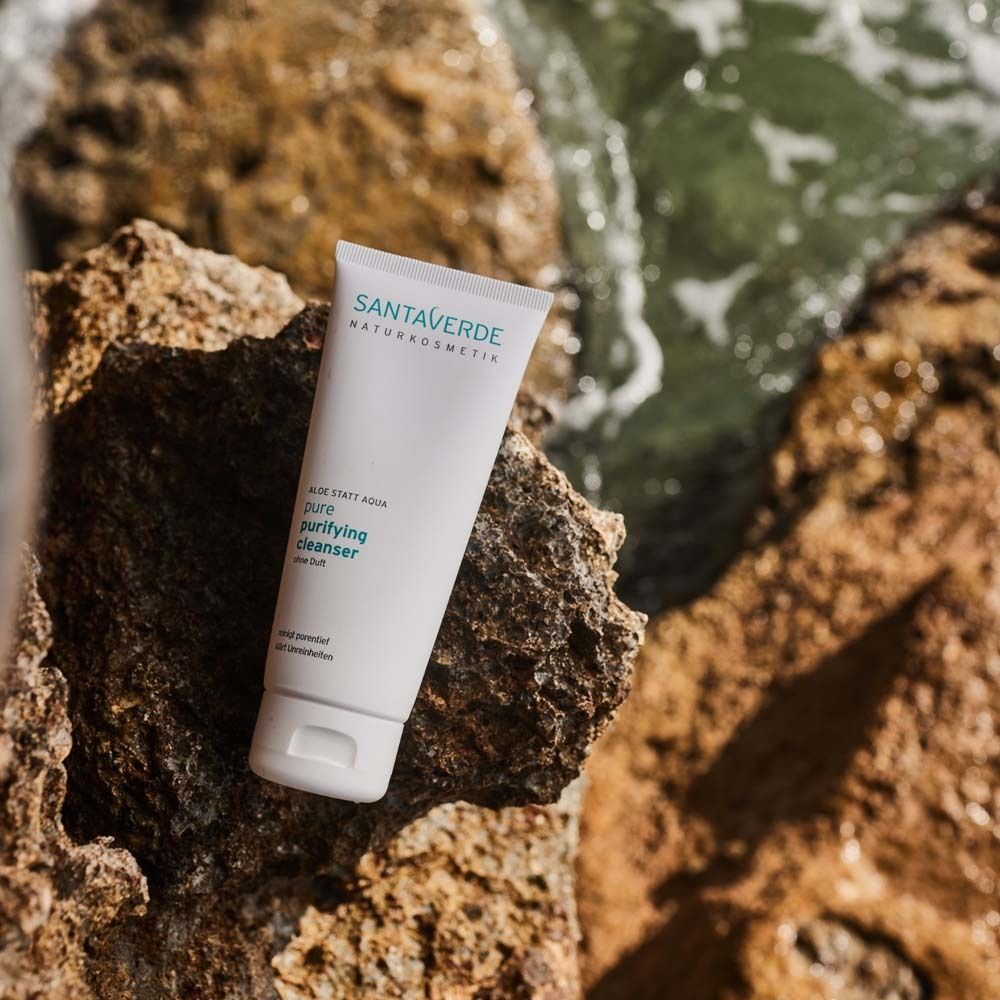 Weiße Tube auf Felsen. SANTAVERDE-Logo und Produktbezeichnung. Text: pure purifying cleanser ohne Duft.
