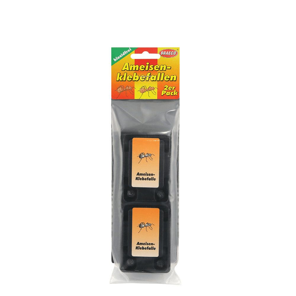 Zwei Ameisen-Klebefallen in Folienverpackung. Schwarze Kunststoffbehälter mit orangefarbenen Etiketten. Aufschrift: Ameisen-Klebefalle.