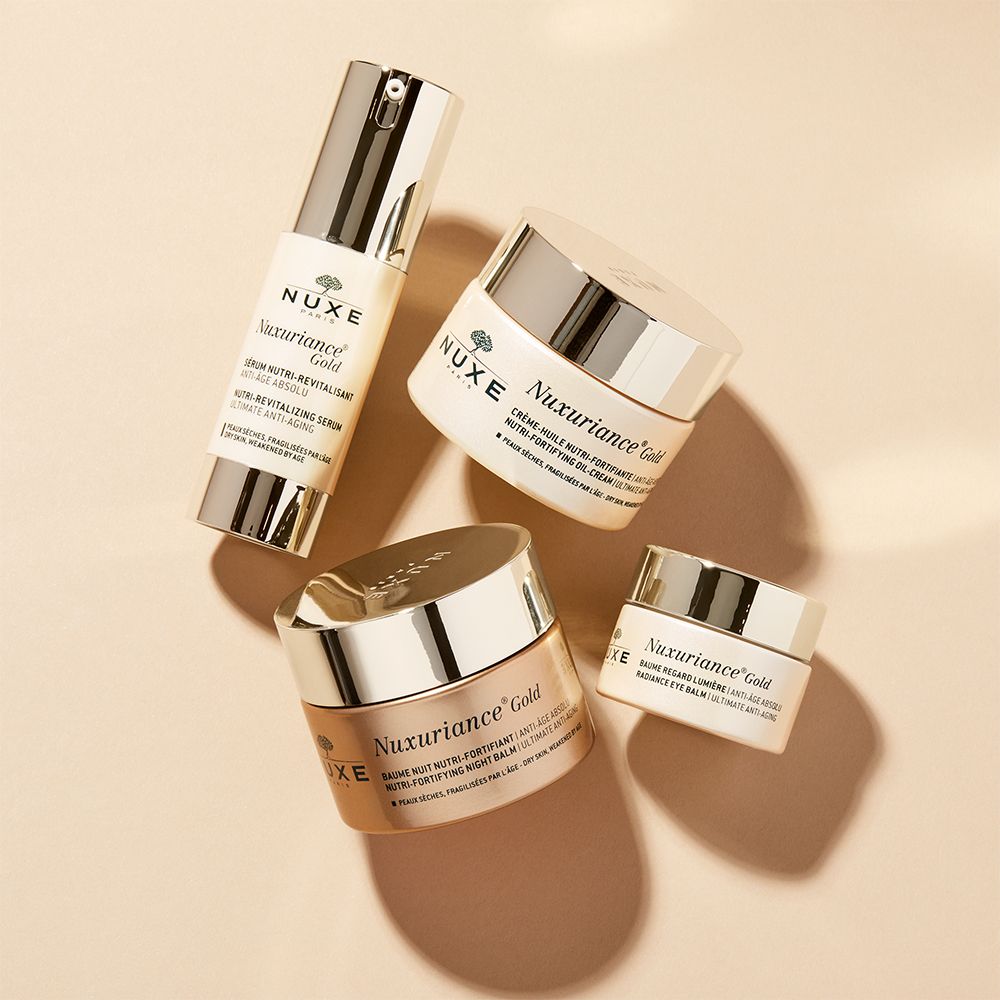 NUXE Produkte: Serum, Augenpflege, Tages- und Nachtcreme. Goldene und weiße Tiegel. Text: Nuxuriance Gold, Super Serum [10].