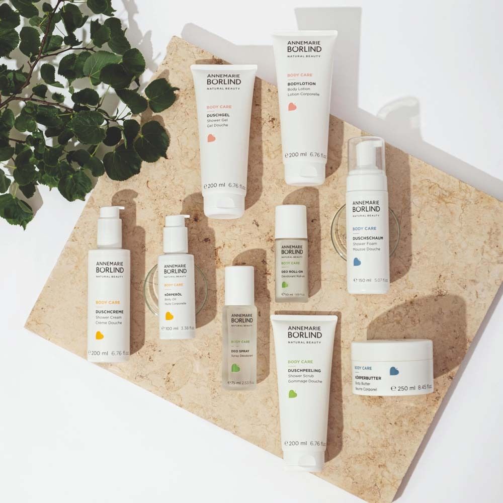 Verschiedene ANNEMARIE BÖRLIND Produkte auf einer Steinplatte. Darunter Body Lotion, Creme, Deospray.