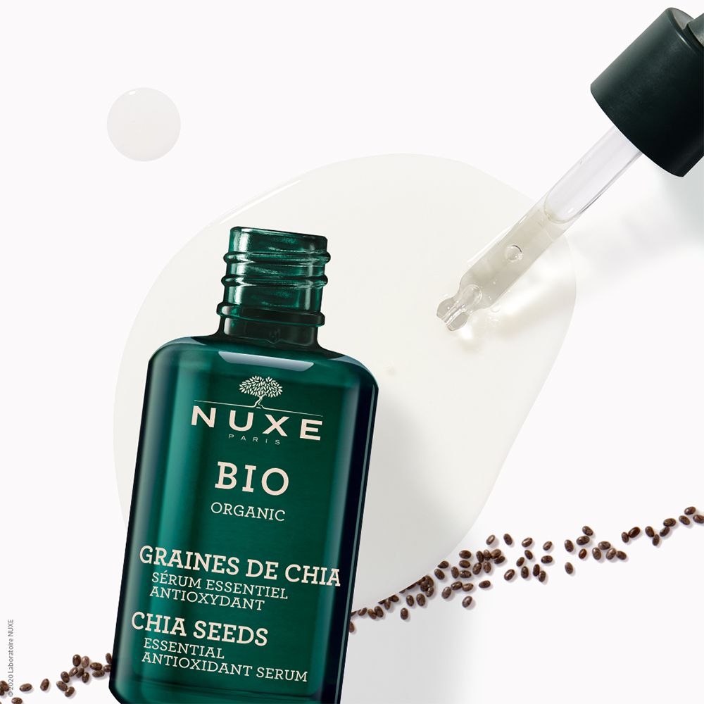 Grüne Glasflasche mit Pipette. Aufschrift: NUXE BIO, GRAINES DE CHIA, Serum essentiel antioxydant.