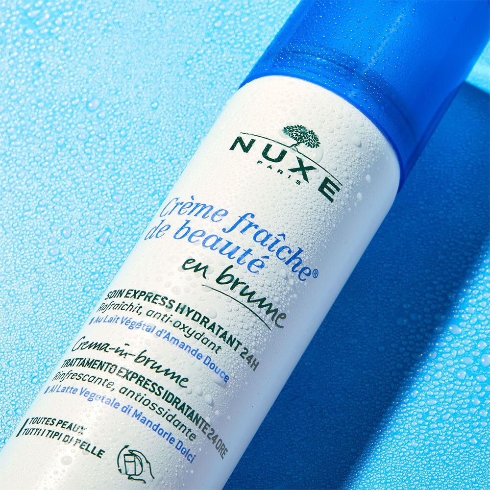 Nahaufnahme der weißen Flasche mit Produktnamen und Logo. Text: Crème fraîche de beauté en brume.