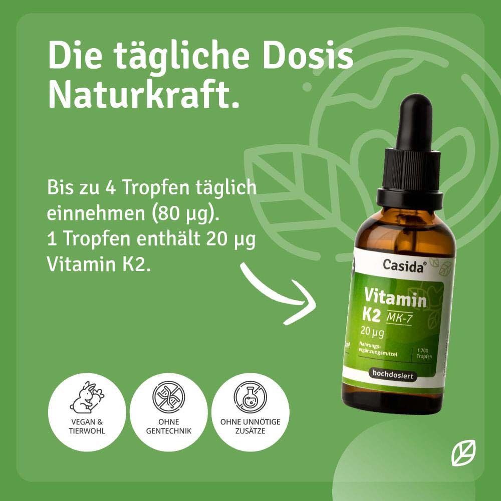 Braunglasflasche mit Tropfer und Karton. Aufschrift: Casida Vitamin K2 MK-7 20 µg. Auf Holzuntergrund.