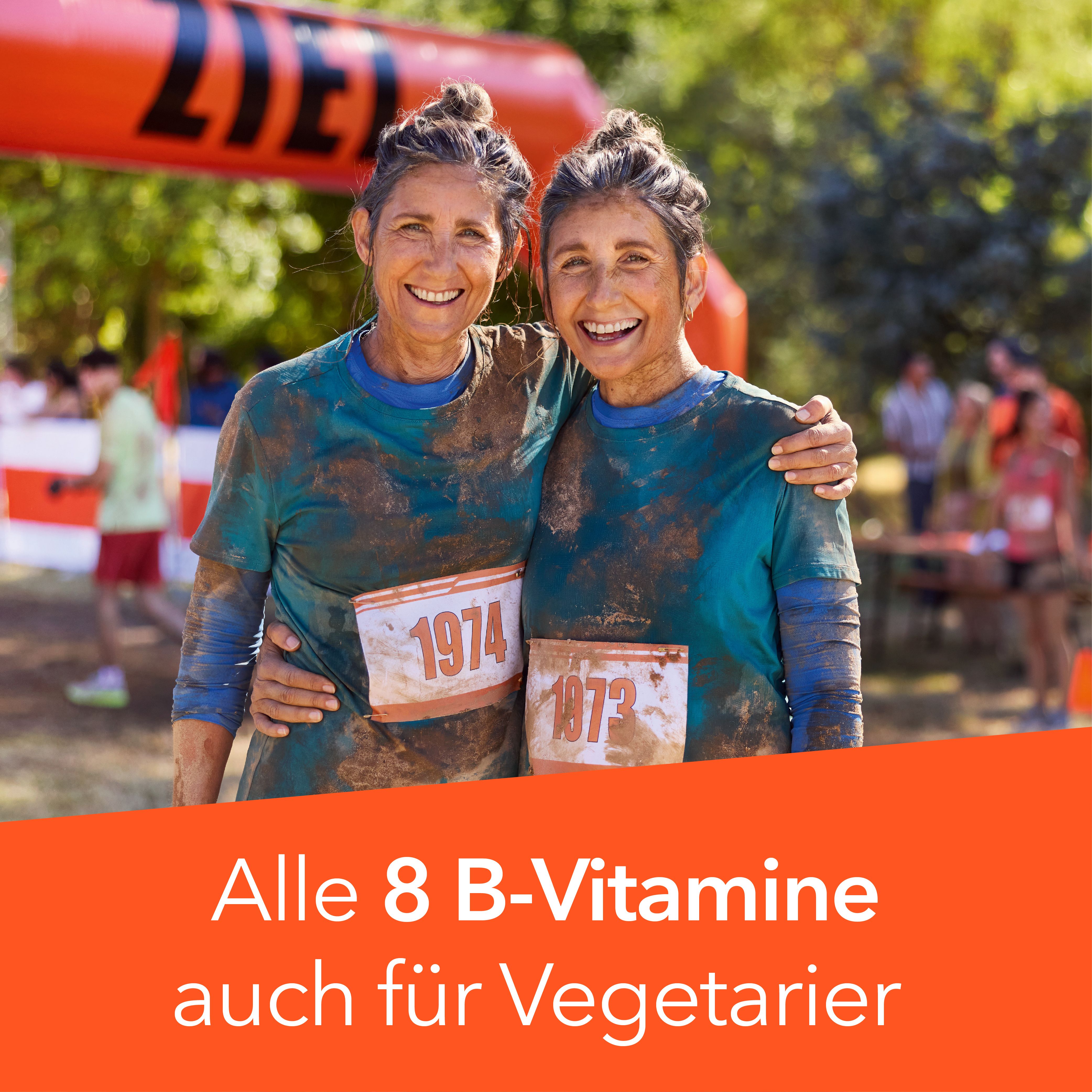 Zwei Frauen umarmen sich, tragen Startnummern. Text: Alle 8 B-Vitamine auch für Vegetarier.