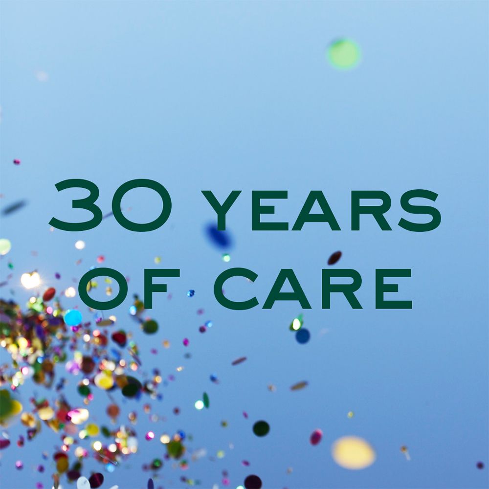 Text: 30 YEARS OF CARE. Grüner Text auf blauem Hintergrund mit Konfetti.