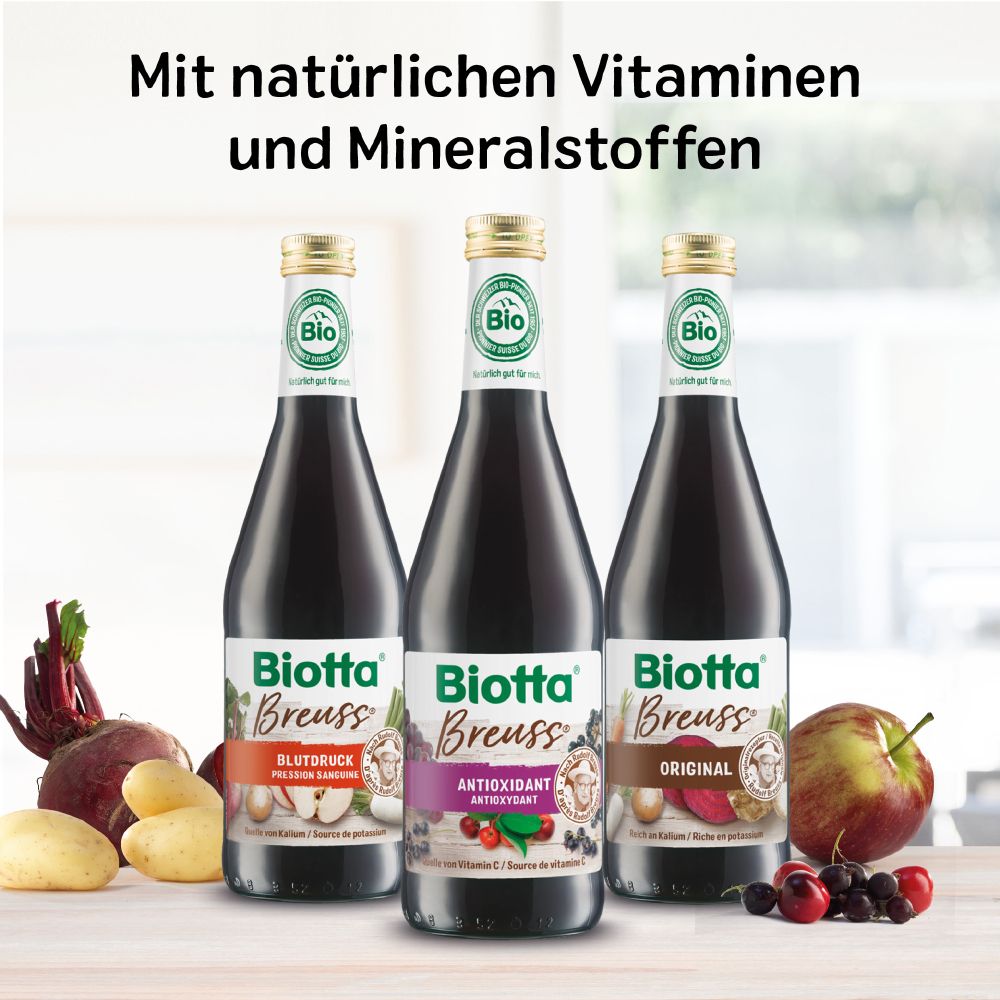 Drei Flaschen Biotta Breuss. Aufschrift: Antioxidant, Original, Bluttruck. Mit Gemüse und Obst.