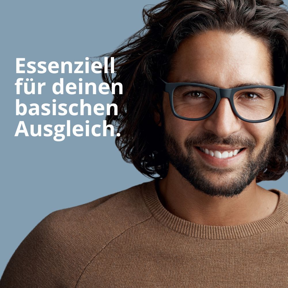 Mann mit Brille lächelt. Text: Essentiell für deinen basischen Ausgleich.