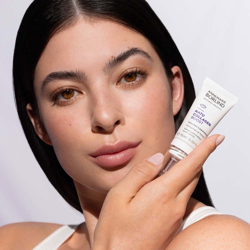 Frau hält Lippen-Serum. Marke: ANNEMARIE BÖRLIND. Produktname: NATU COLLAGEN BOOST. Frau mit hellem Teint.