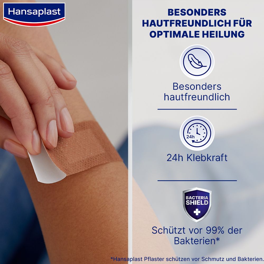 Person zeigt Anwendung eines Hansaplast Sensitive Pflasters am Arm. Pflaster ist beige und rechteckig. Text: 24h Klebkraft.
