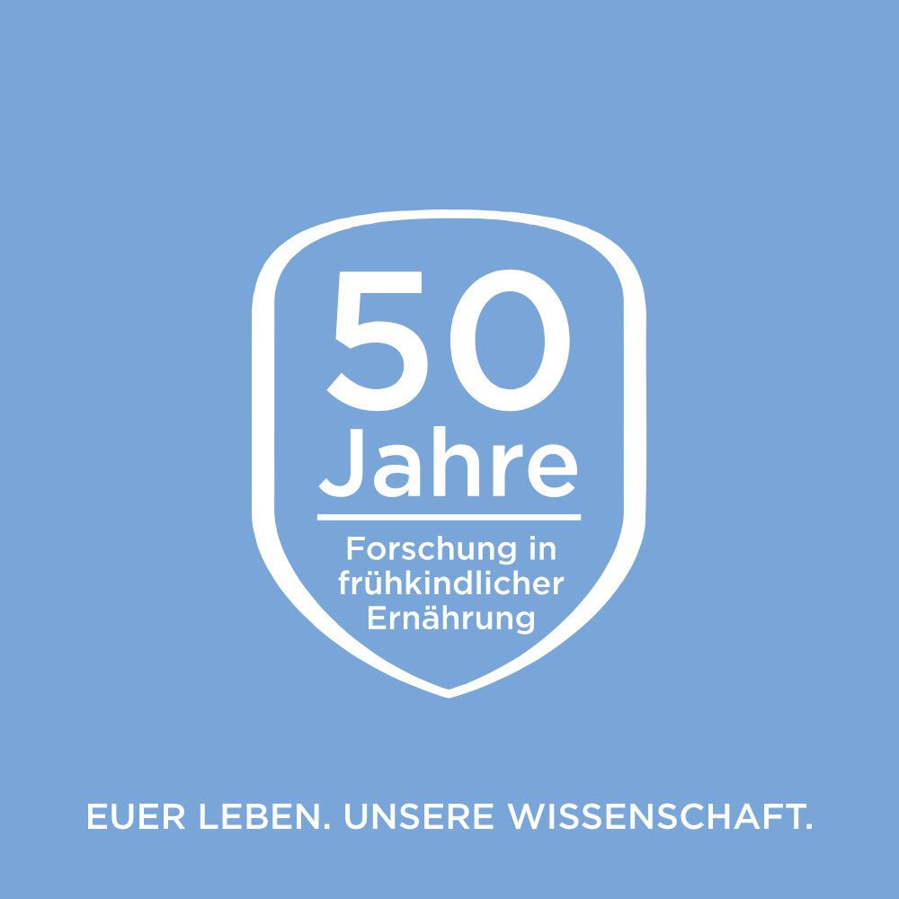 Weißes Schild mit der Aufschrift 50 Jahre Forschung in frühkindlicher Ernährung. Auf blauem Hintergrund.