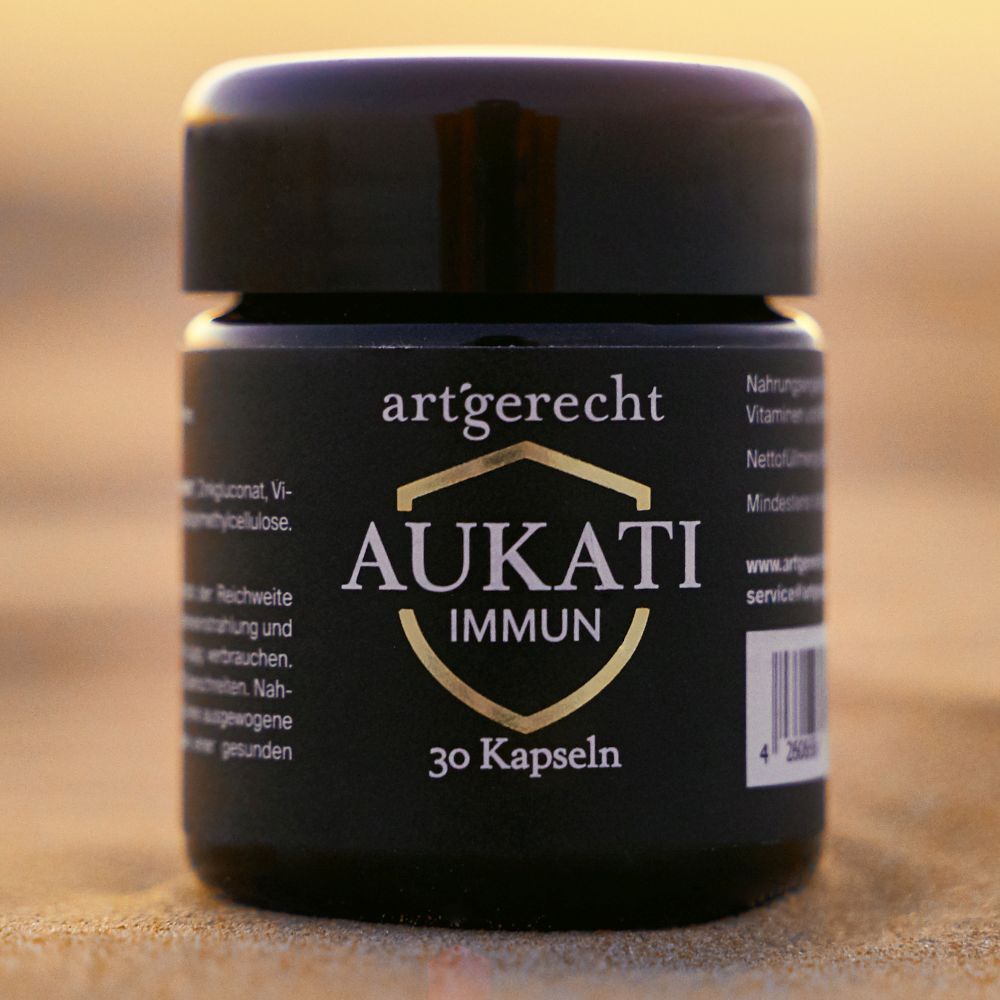 Schwarze Dose mit Aufschrift AUKATI IMMUN, 30 Kapseln, auf Sand. Schwarzer Deckel.