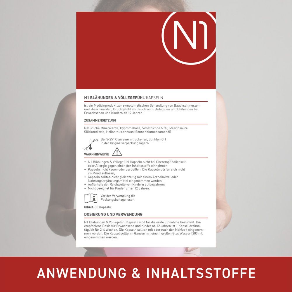 Person hält Produktinformationen zu N1 Blähungen & Völlegefühl Kapseln.
