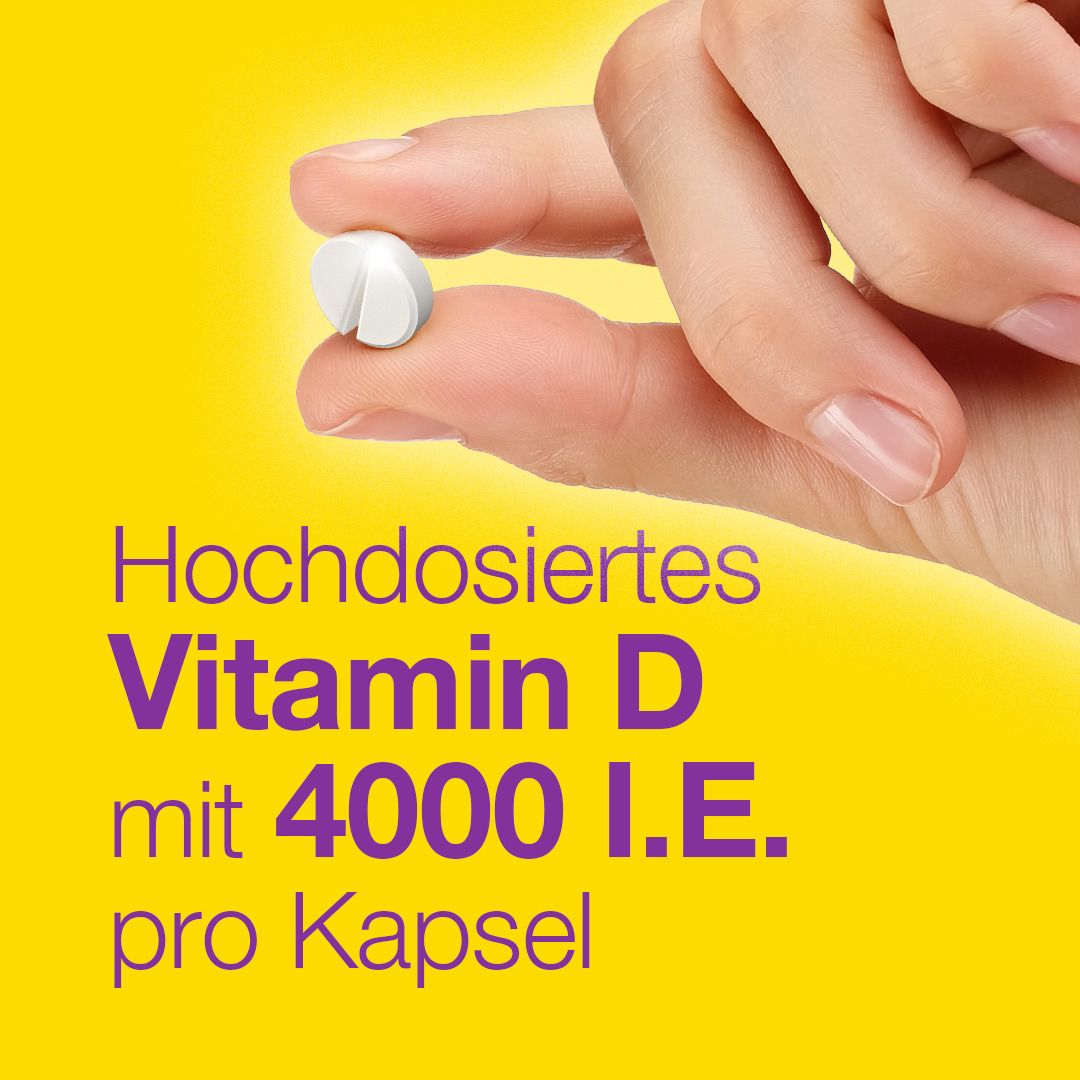 Hand hält Tablette. Gelber Hintergrund. Text: Hochdosiertes Vitamin D mit 4000 I.E. pro Kapsel.