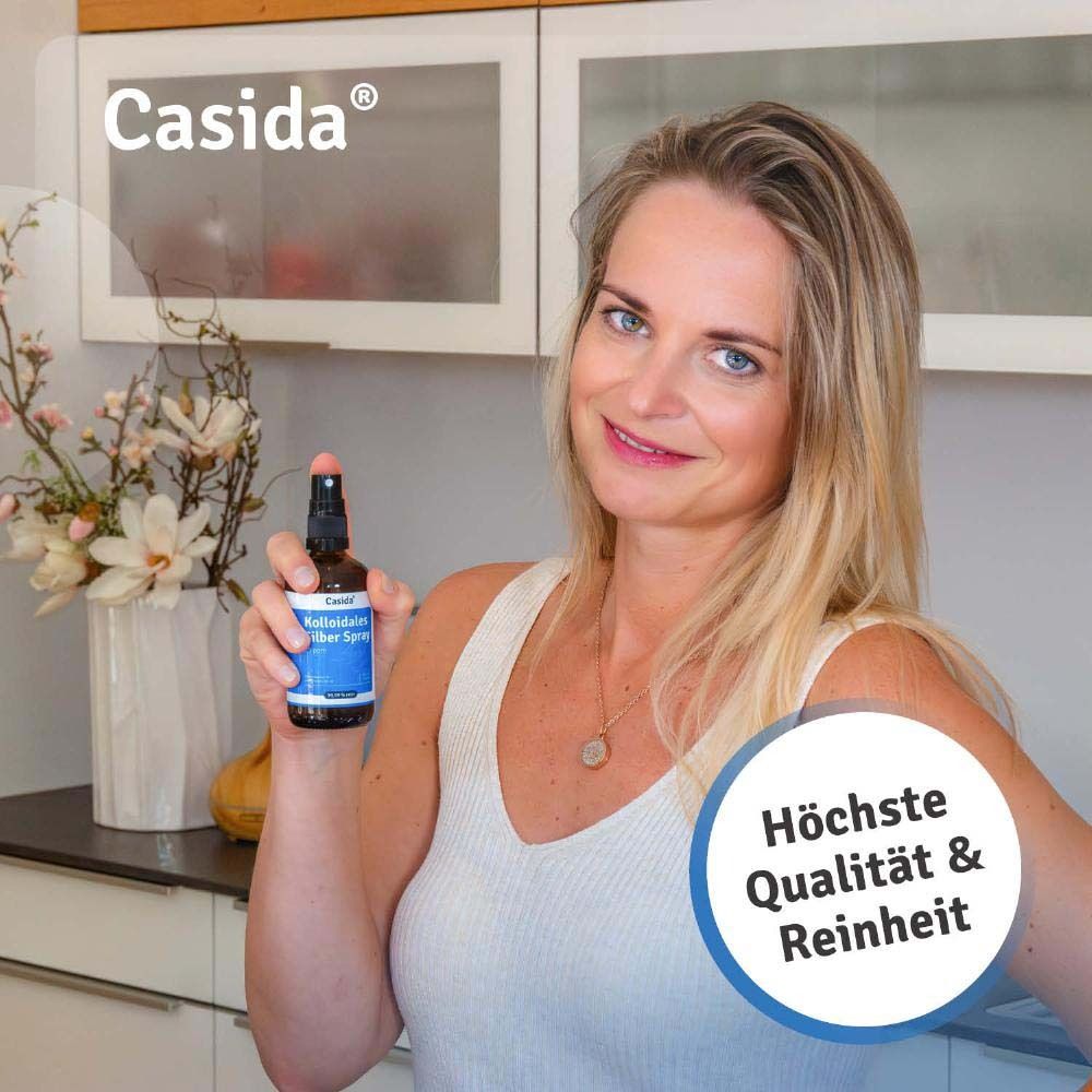 Frau hält eine Flasche Kolloidales Silber Spray. Aufschrift: Casida, höchste Qualität & Reinheit.