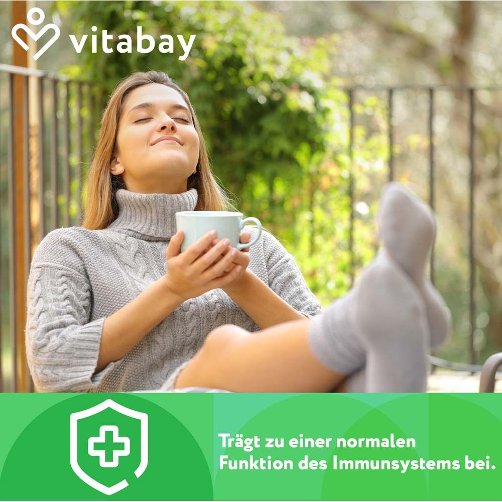 Frau mit geschlossenen Augen hält eine Tasse. Text: Trägt zu einer normalen Funktion des Immunsystems bei. vitabay-Logo.