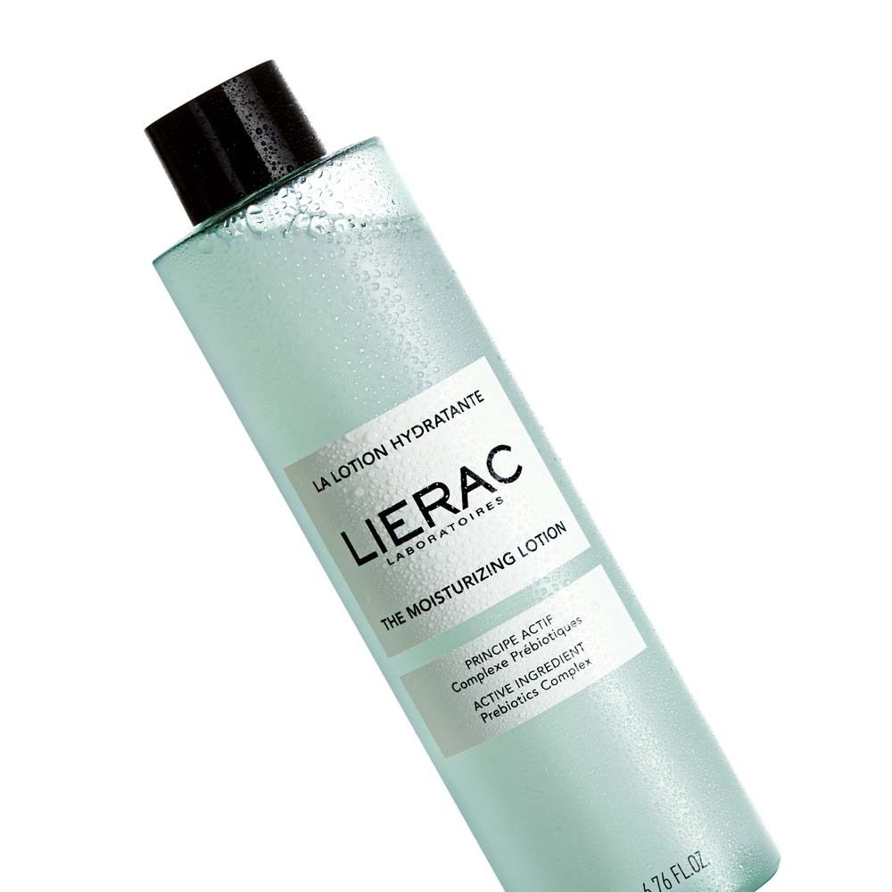 Türkisgrüne Flasche mit schwarzem Deckel. Aufschrift: LIERAC, THE MOISTURIZING LOTION. Enthält Prebiotics Complex. Schräg.