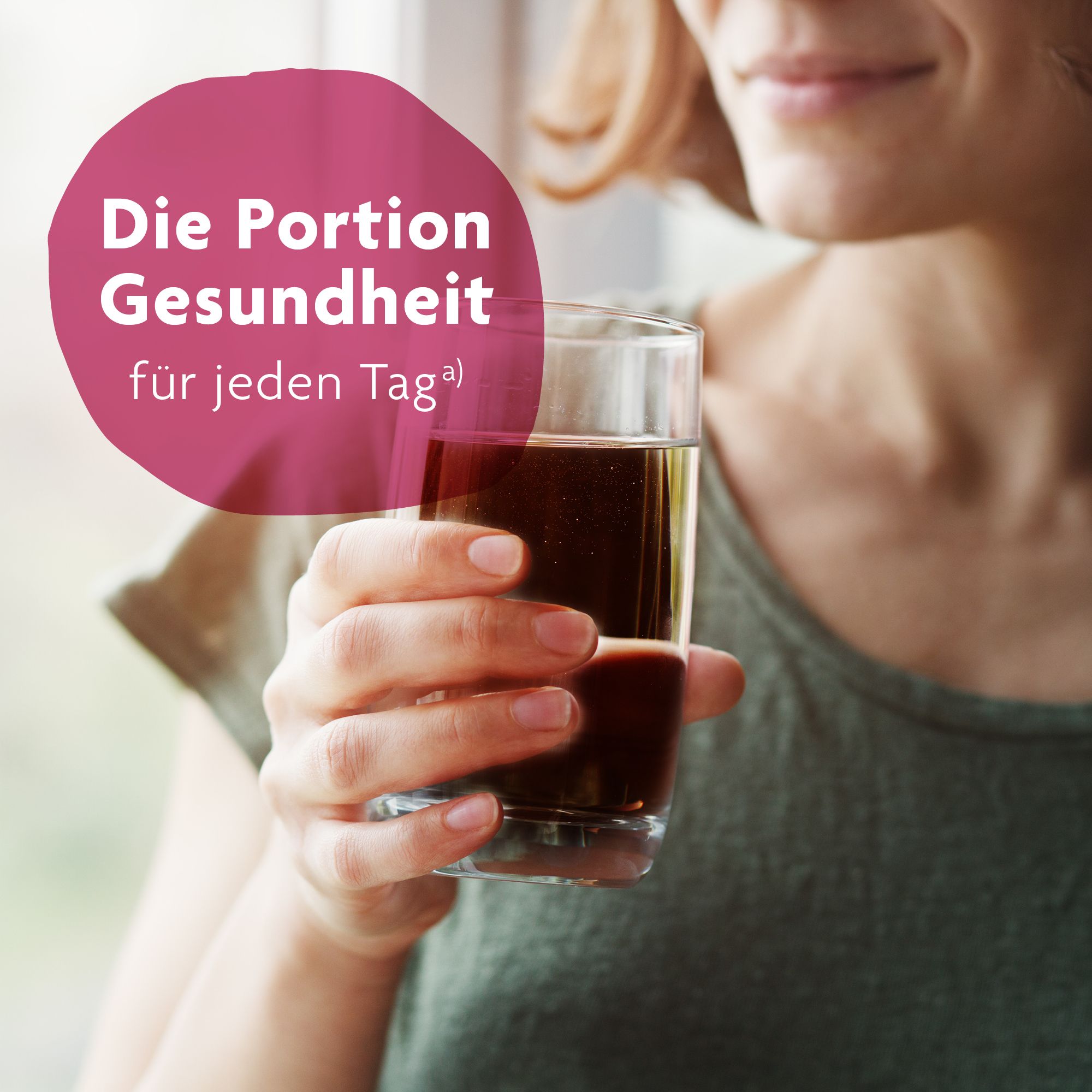 Glas mit Flüssigkeit, gehalten von einer Person. Text: Die Portion Gesundheit für jeden Tag.