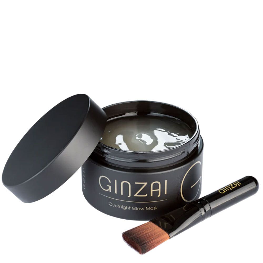 Schwarzer Tiegel mit geöffnetem Deckel, Maske und Pinsel. Schriftzug GINZAI Overnight Glow Mask.