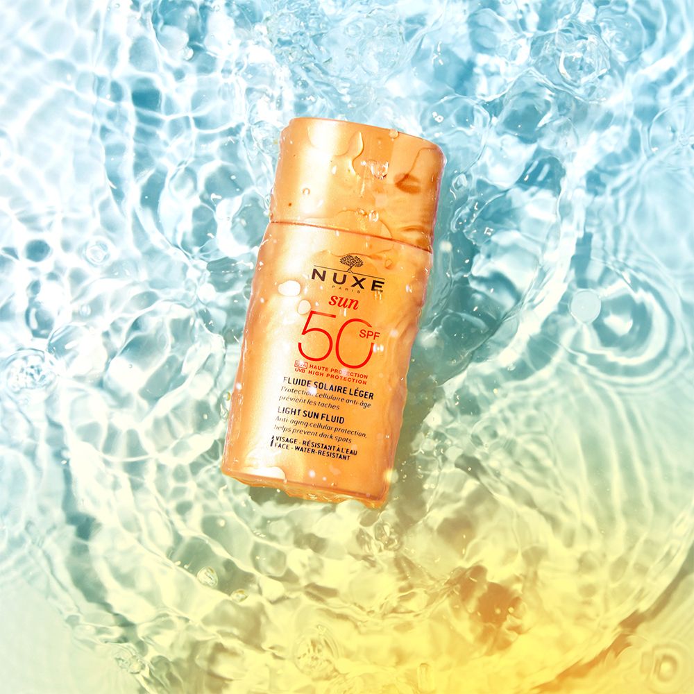 Sonnenfluid-Flasche im Wasser. Aufschrift: NUXE Sun, SPF 50. Text: Fluide solaire léger, Light Sun Fluid.