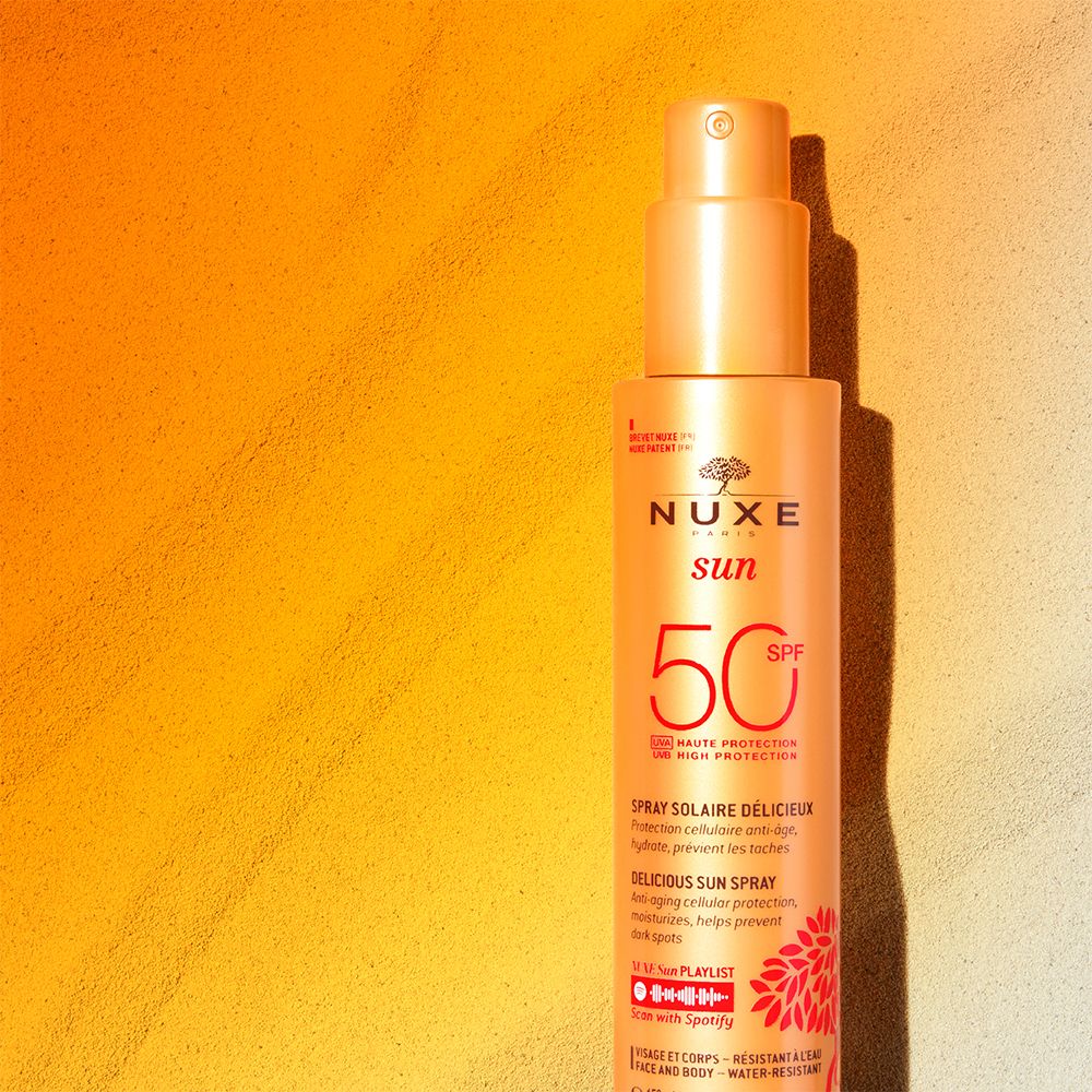 Sonnenspray auf gelb-weißem Hintergrund. NUXE Sun, LSF 50. Produktinformationen.