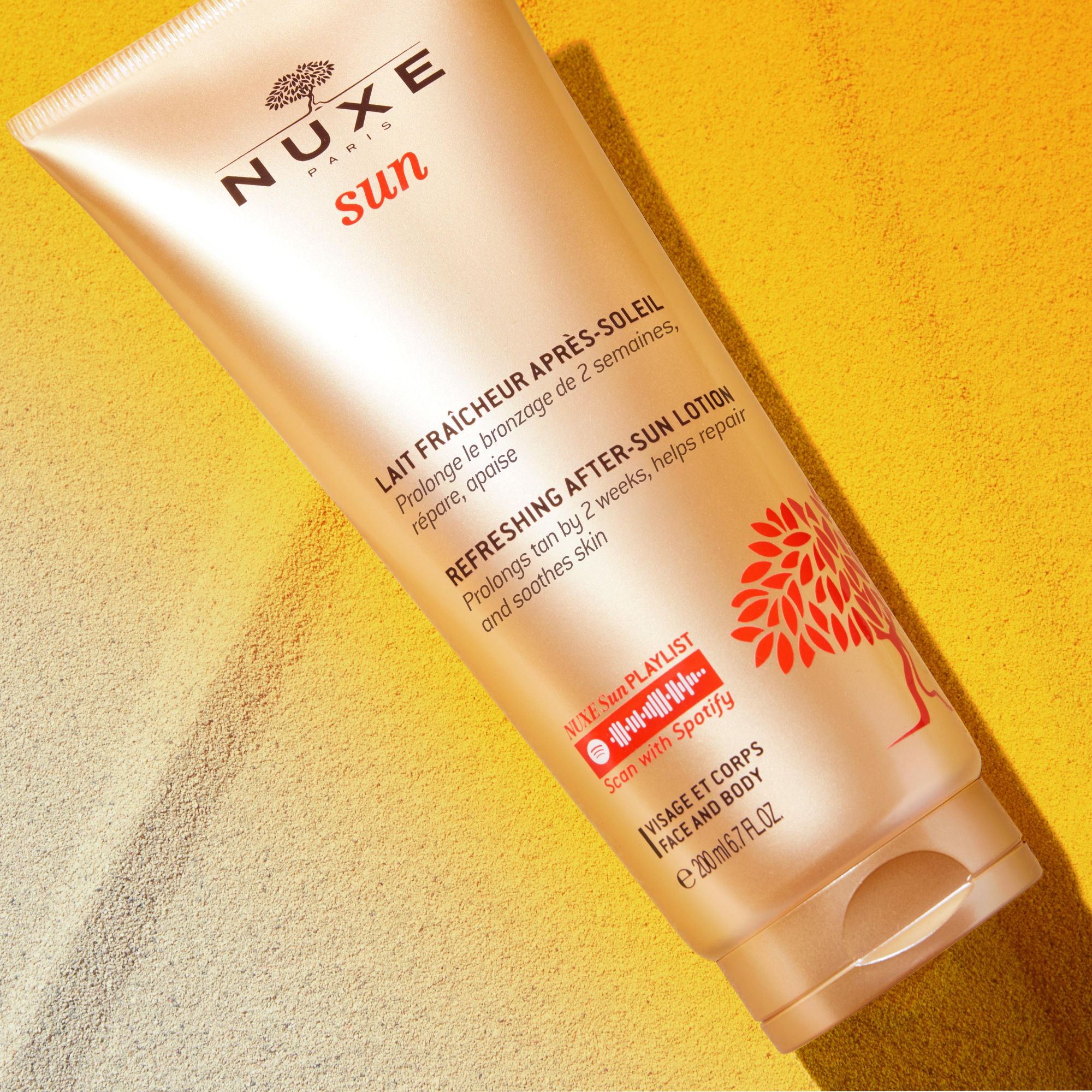 Tube NUXE Sun After-Sun-Lotion auf gelbem Hintergrund. Produktinformationen und Logo sichtbar.