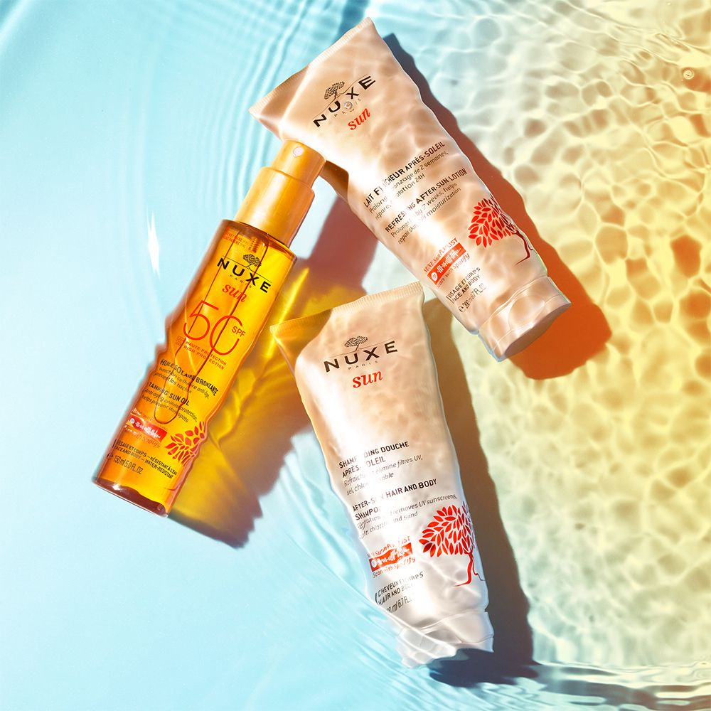 Drei NUXE Sun Produkte im Wasser. Sonnenöl, After-Sun-Lotion und After-Sun-Milch.
