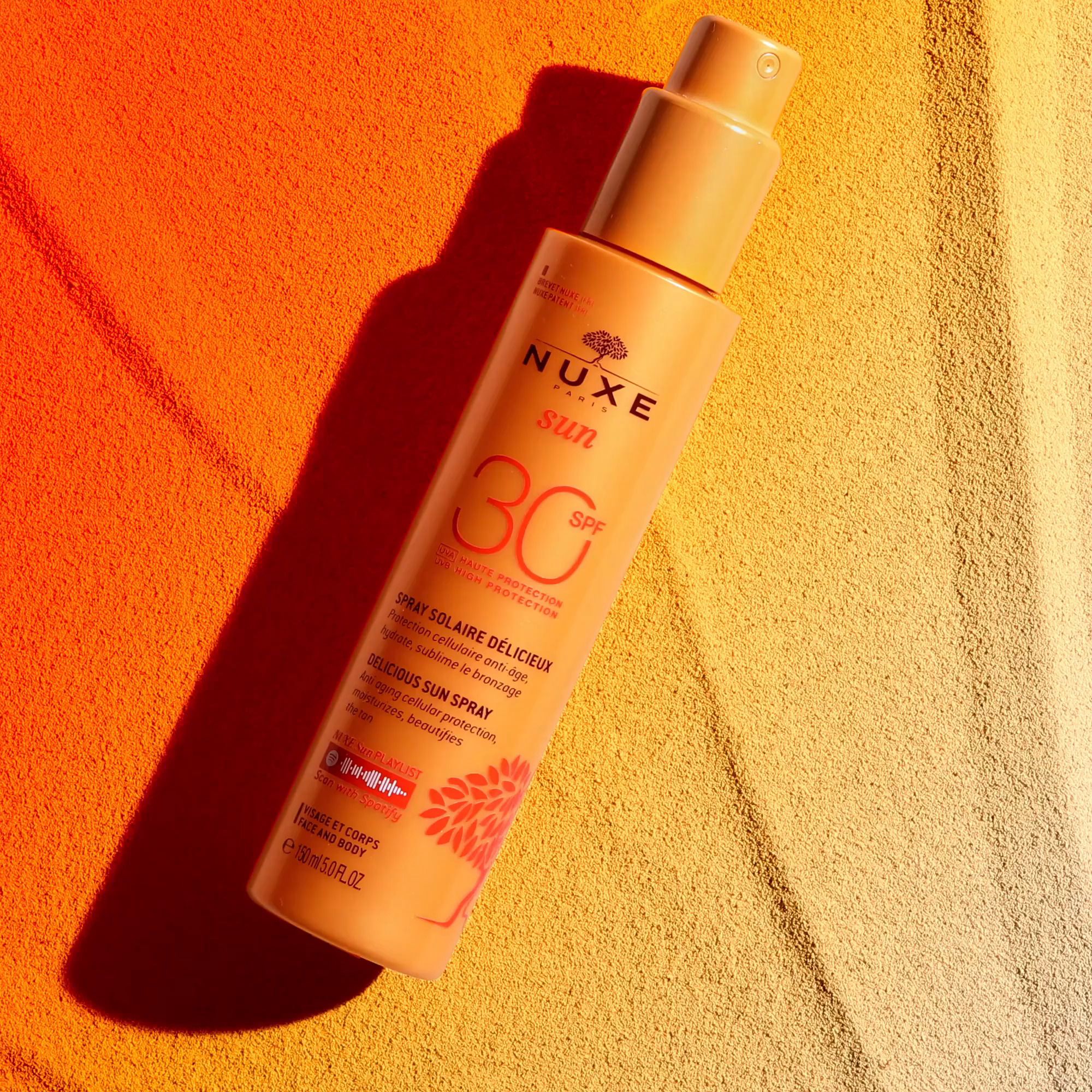 Gelbe Sprayflasche auf gelb-orangem Hintergrund. Aufschrift: NUXE Sun, SPF 30. Text: Spray Solaire Délicieux.