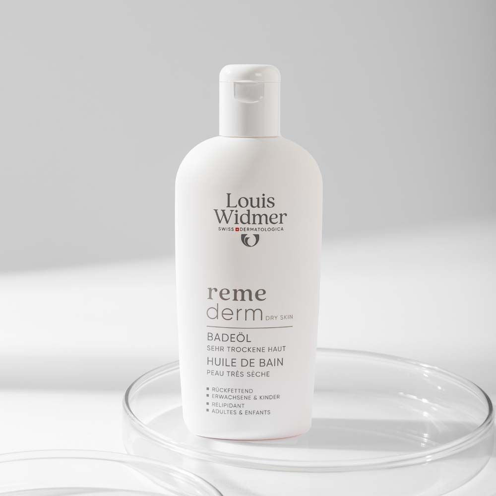 Weiße Flasche Badeöl auf Glasplatte. Text: Louis Widmer, remederm, Badeöl, sehr trockene Haut.